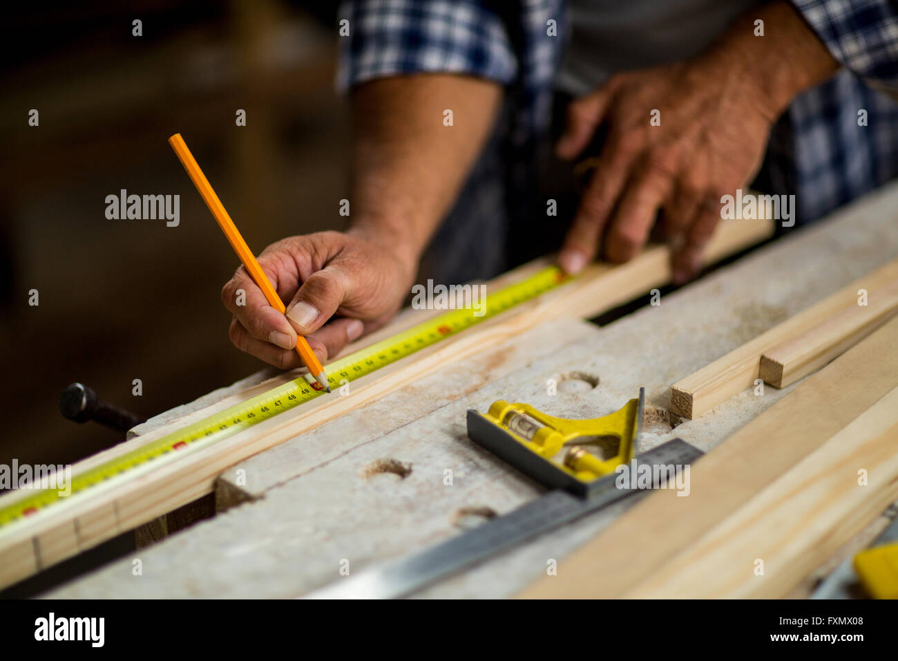Carpenter marking on wooden plank with pencil Stock Photo Alamy