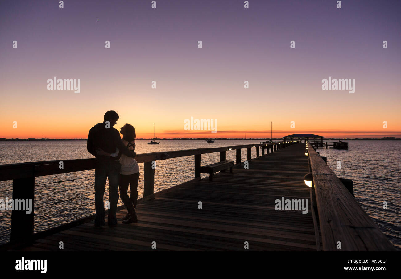 Couple on pier at sunset, Melbourne Beach, Atlantic Coast,  Florida Stock Photo
