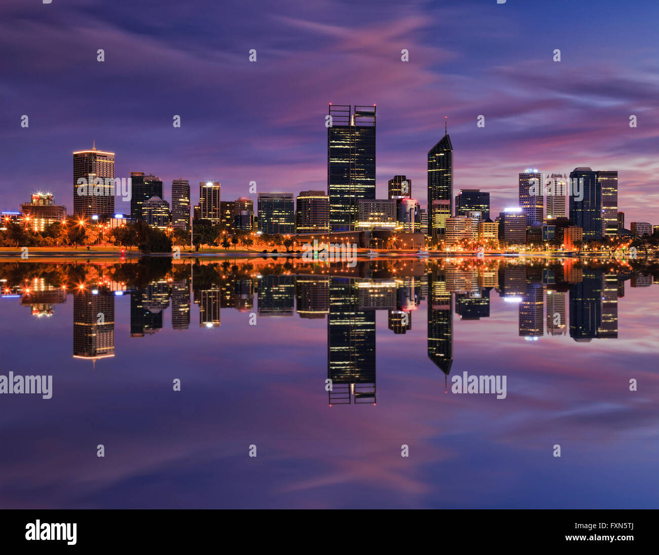 Mirror like reflection of Perth city CBD towers and skyscrapers in still waters of Swan river at sunrise with pink clouds Stock Photo