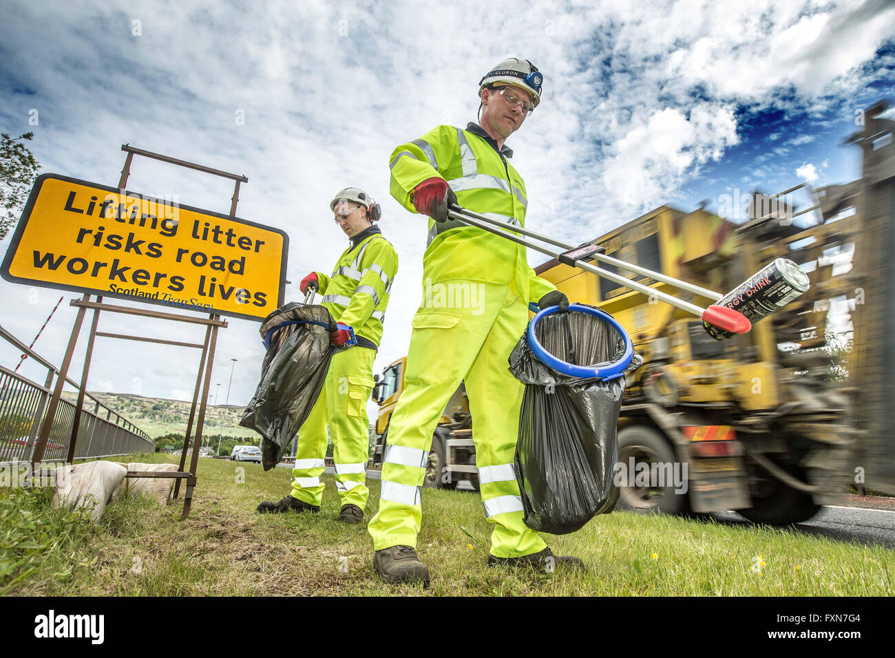 Litter picking by roadside Stock Photo Alamy