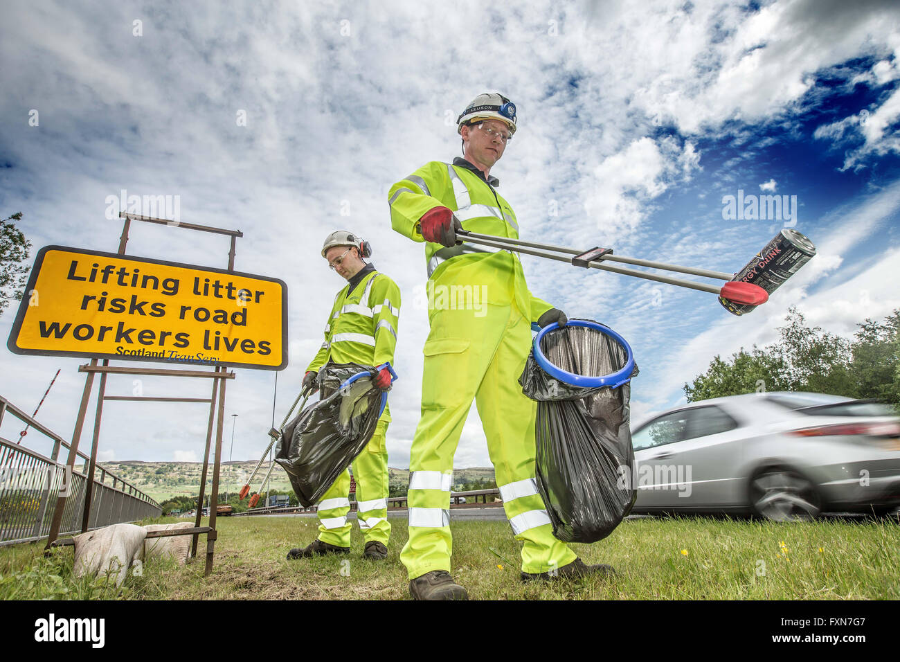 Litter picking by roadside Stock Photo Alamy