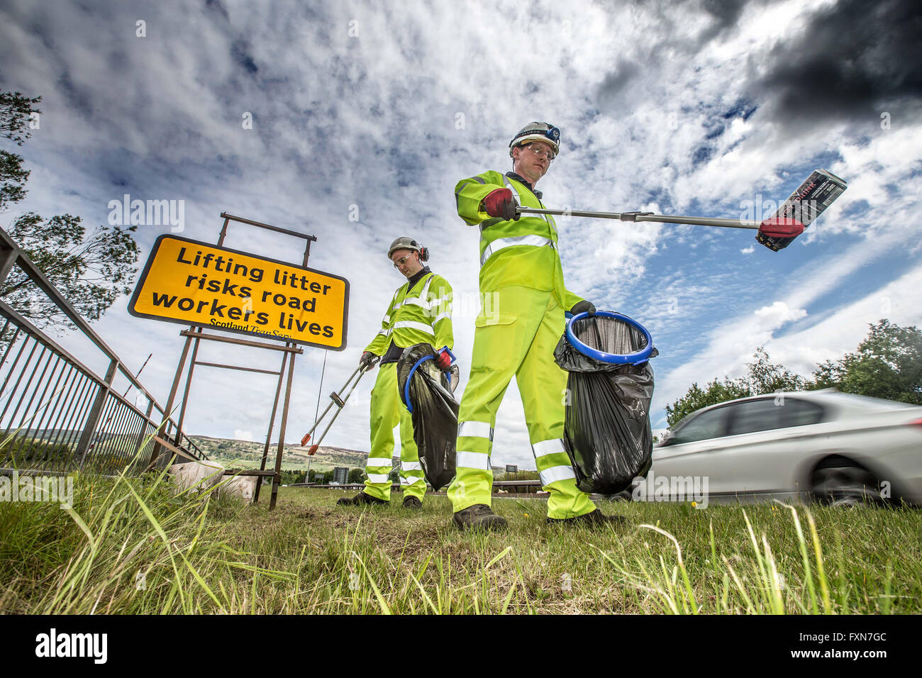 Litter picking by roadside Stock Photo Alamy