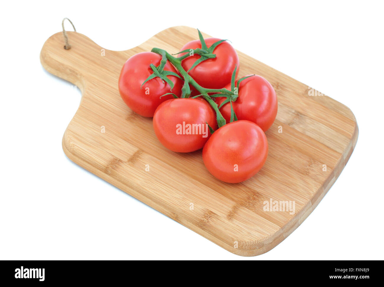 Tomatoes on a wooden cutting board Stock Photo