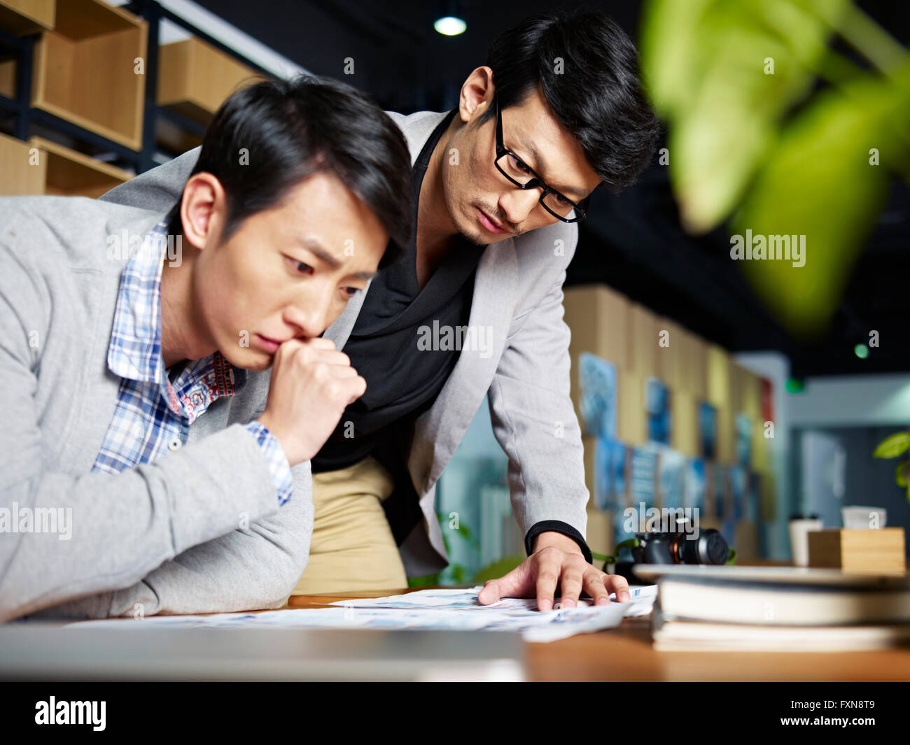 asian photographers designers working in studio. Stock Photo