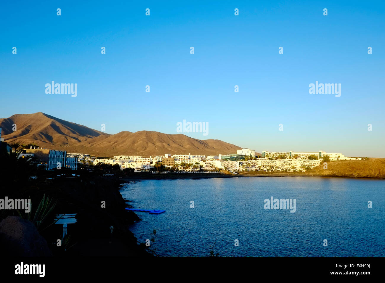 A view of the Sandos Papagayo hotel at Playa Blanca Lanzarote from across the bay on a beautiful warm evening Stock Photo