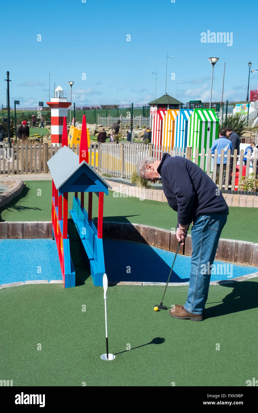 Seaside mini-golf, crazy, playing, silly, crazy, putter, action, recreation, summer, miniature golf,sport, ball, leisure, hole, club, fun course, UK Stock Photo