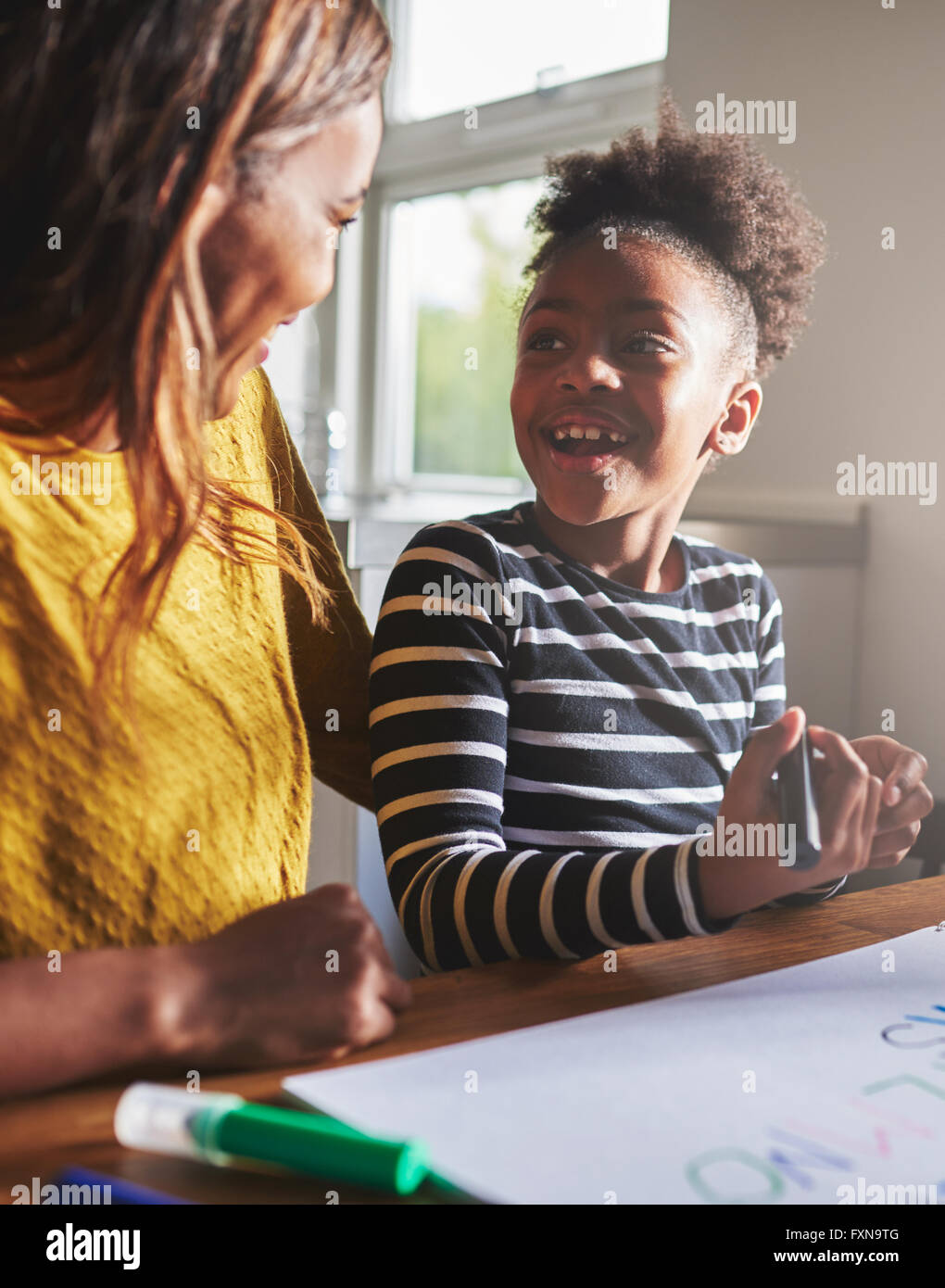 Happy child learning the alphabet with her mother, black woman and child Stock Photo