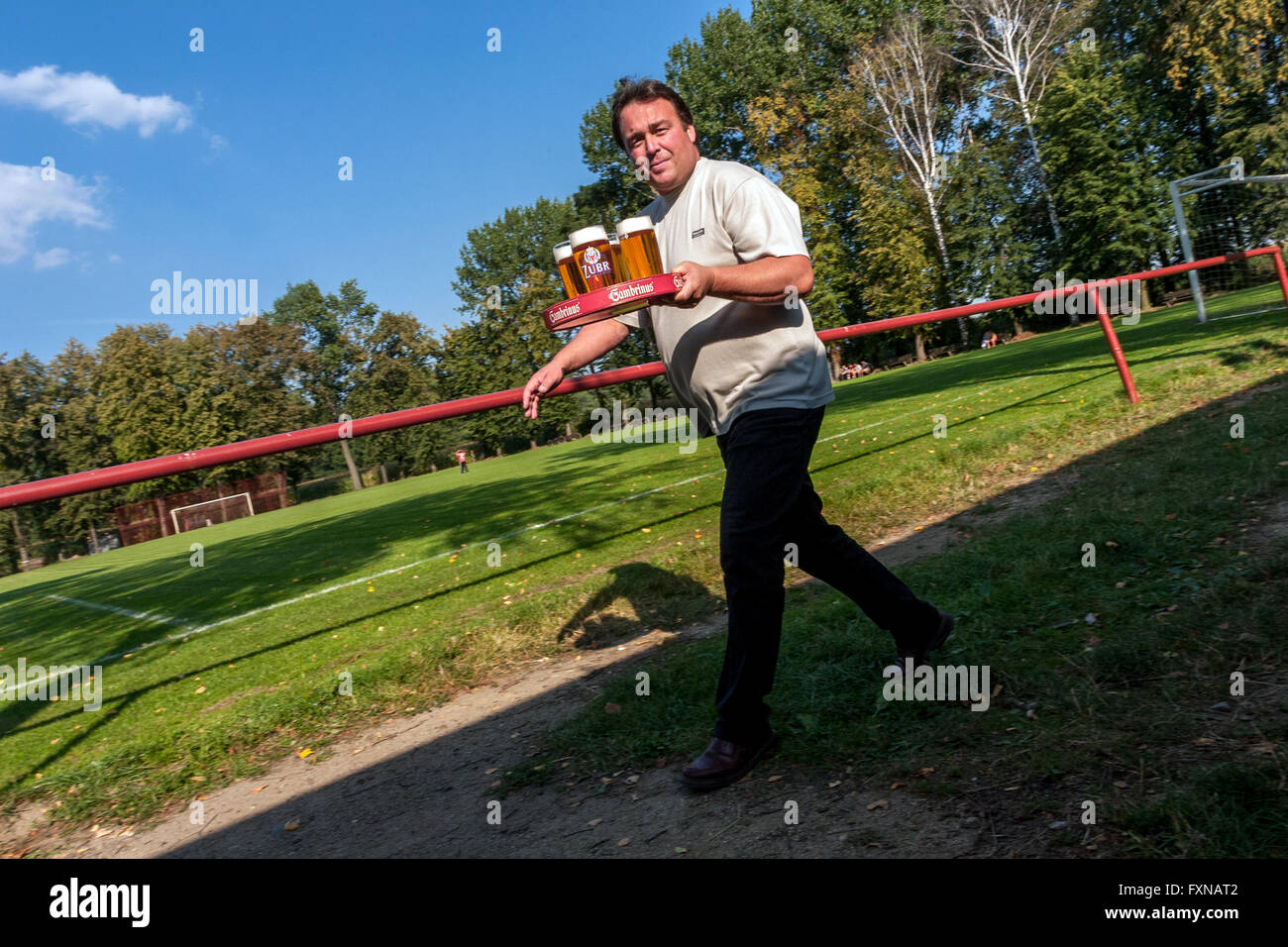 Waiter serving beer, a man carries a tray of beer brand Zubr. Moravian village, Czech Republic football in a small rural village, lifestyle Stock Photo