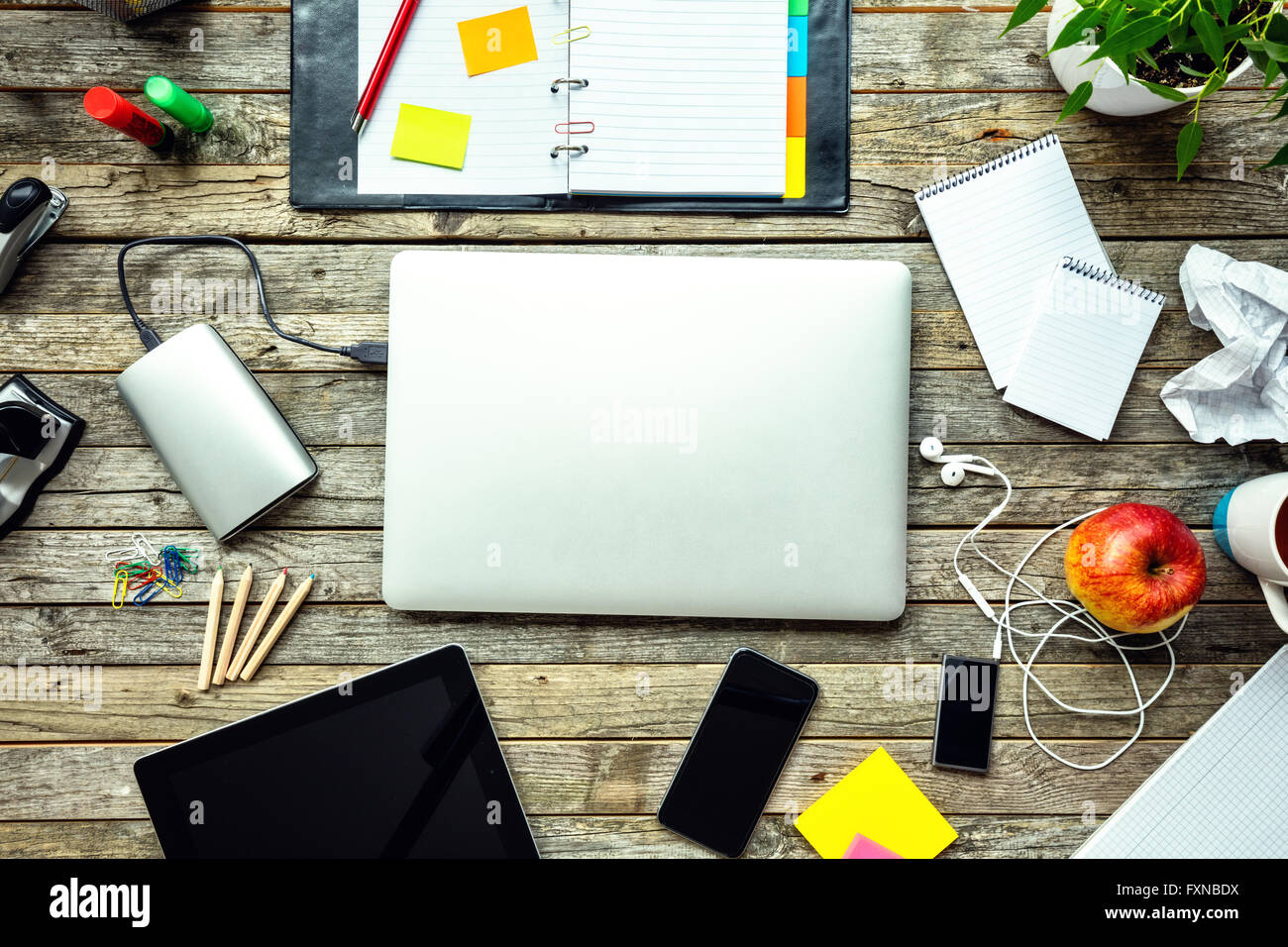 Laptop with other modern electonic devices on desk Stock Photo