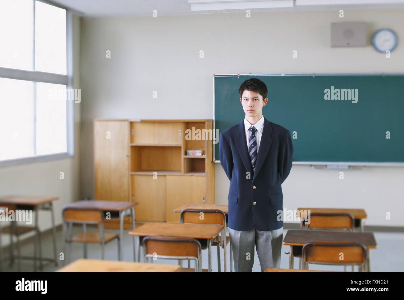 Japanese highschool student in front of classroom blackboard Stock