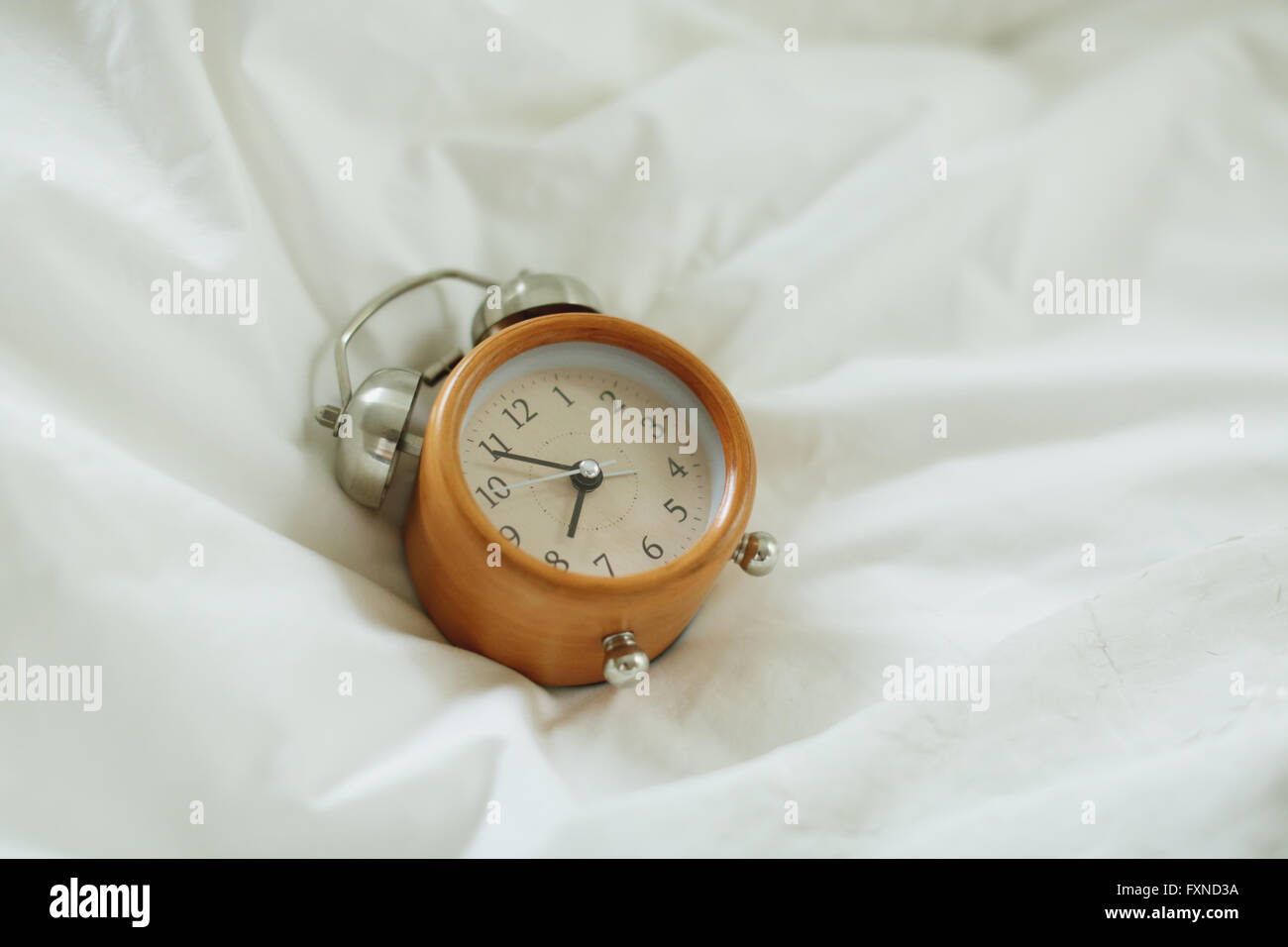 Alarm clock on bed Stock Photo Alamy