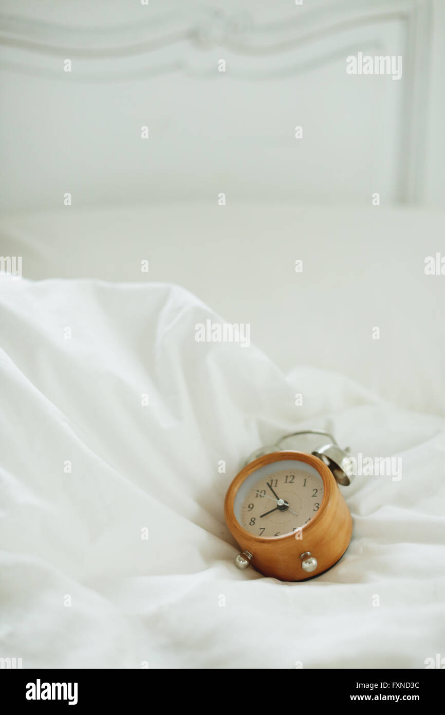 Alarm clock on bed Stock Photo Alamy