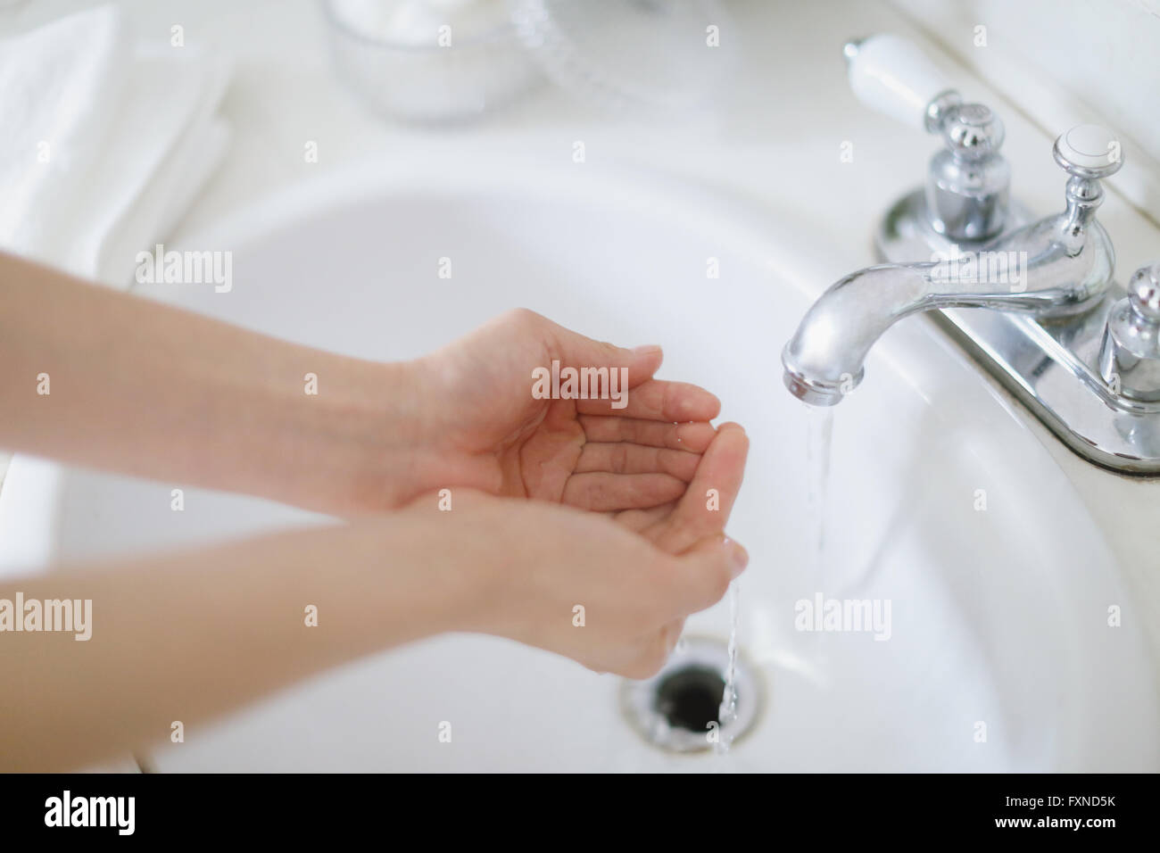 Young attractive Japanese woman washing face in the bathroom Stock Photo