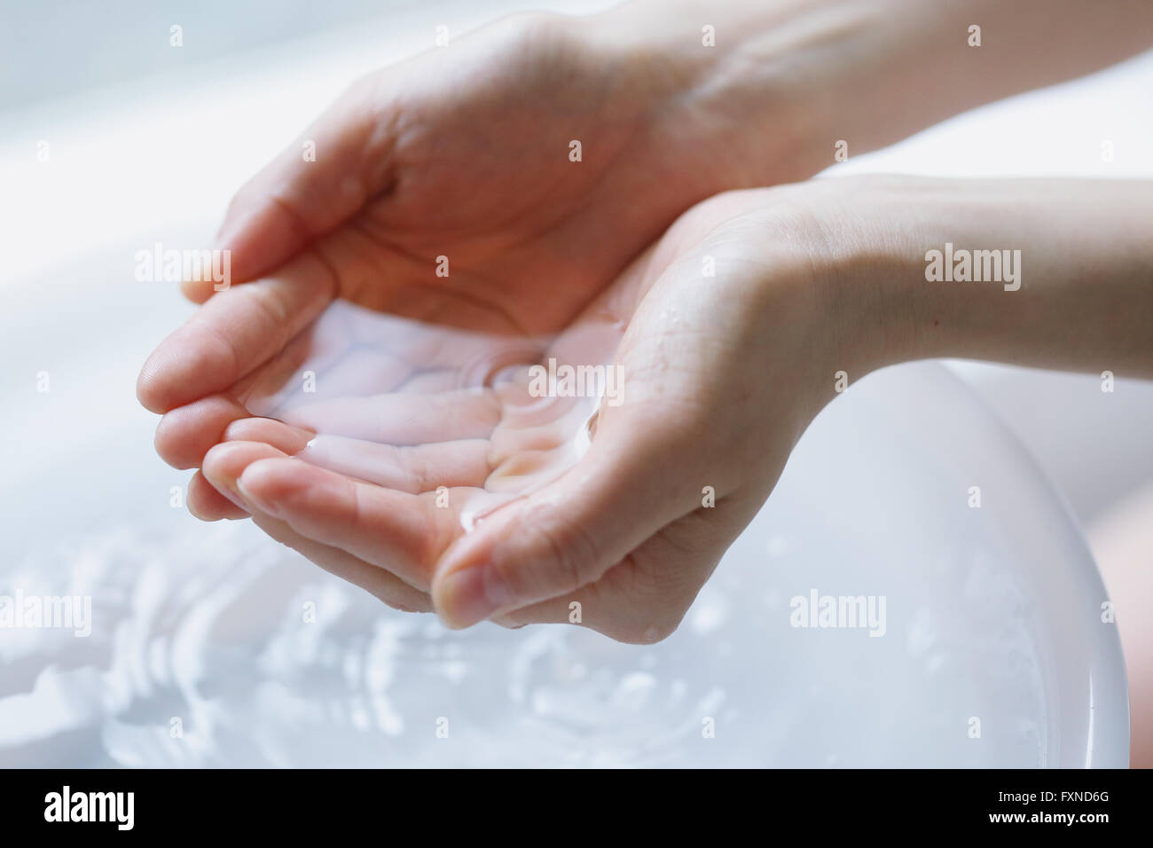 Young attractive Japanese woman washing face in the bathroom Stock