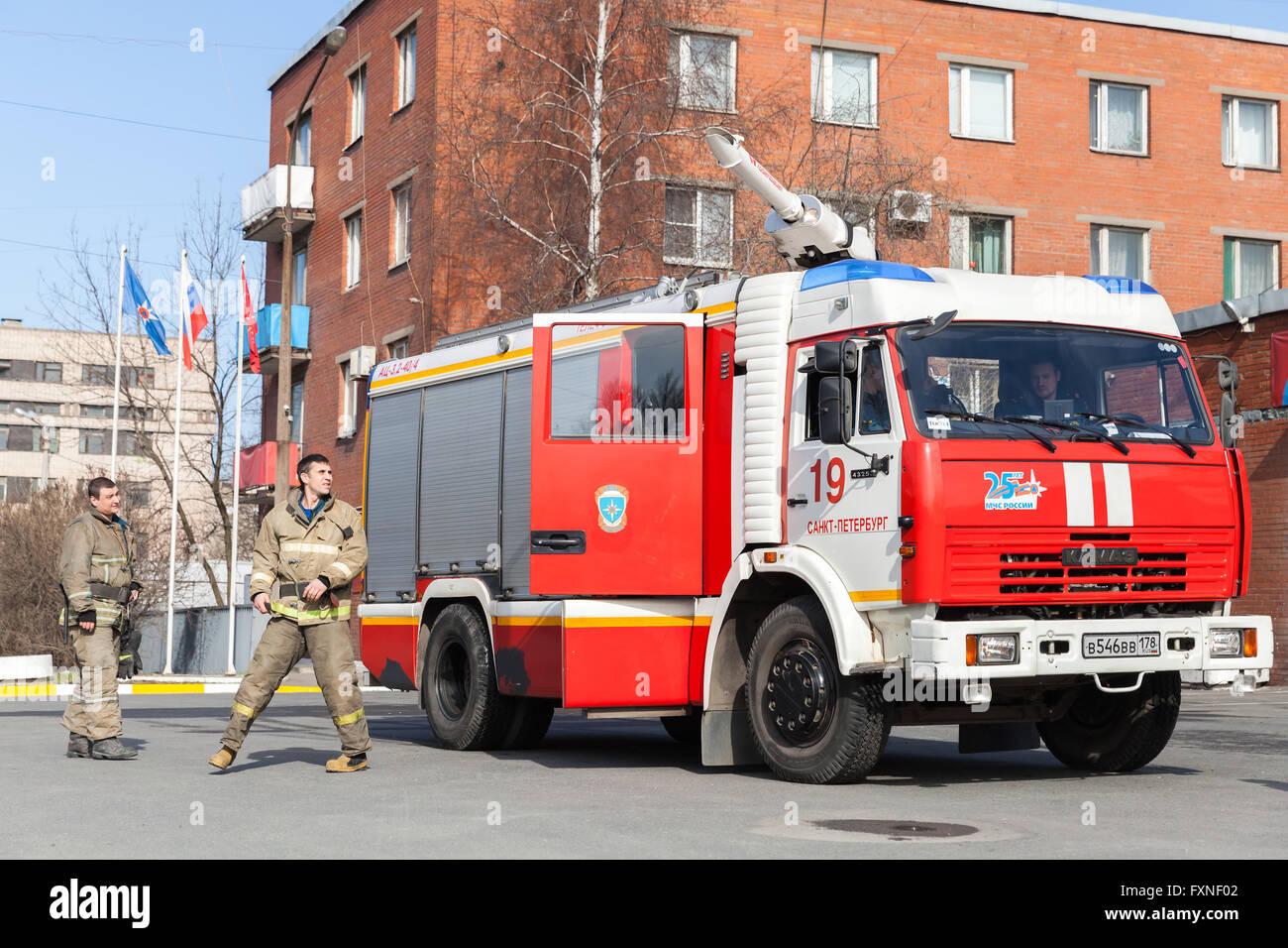 St. Petersburg, Russia - April 9, 2016: Kamaz 43253 truck, red Russian fire engine modification with firemen nearby Stock Photo
