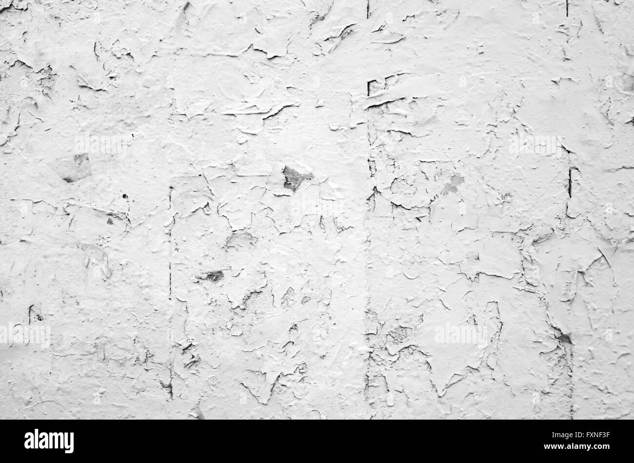 Cracked flaking white paint on old stone wall, background photo texture Stock Photo