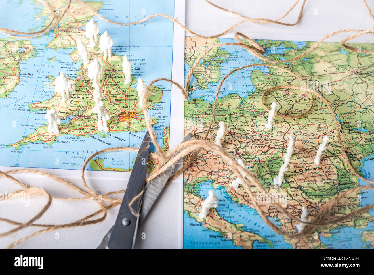 Figures of people standing on maps of UK and Europe, symbolizing making decision about Brexit, scissors cutting rope Stock Photo
