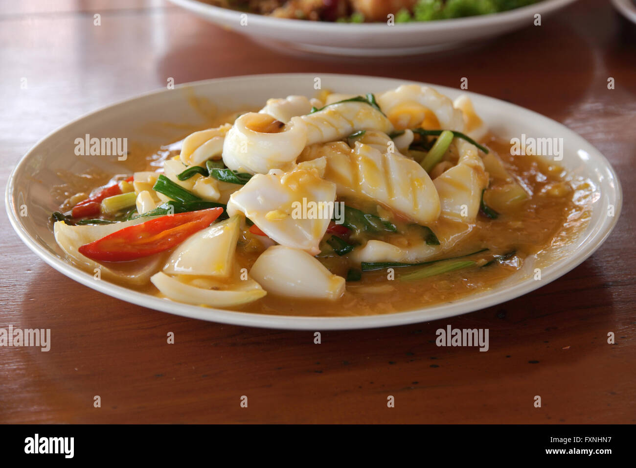 Stir fried squid with salted eggs on wood table Stock Photo