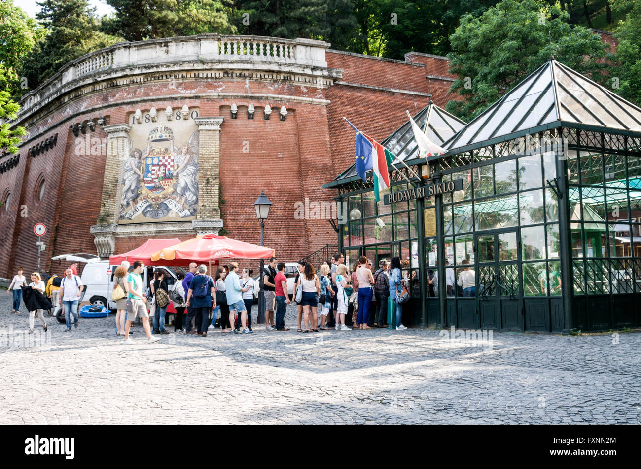 A line of tourists queues at the funicular terminal at the foot of Castle Hill on the Buda side of Budapest in Hungary.  On the l Stock Photo