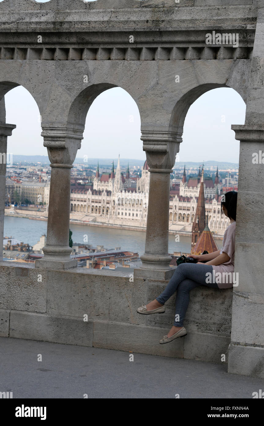 A young Asian tourist admires the city view from the Fishermen's Bastion at Buda Castle hill in Budapest, Hungary. Stock Photo