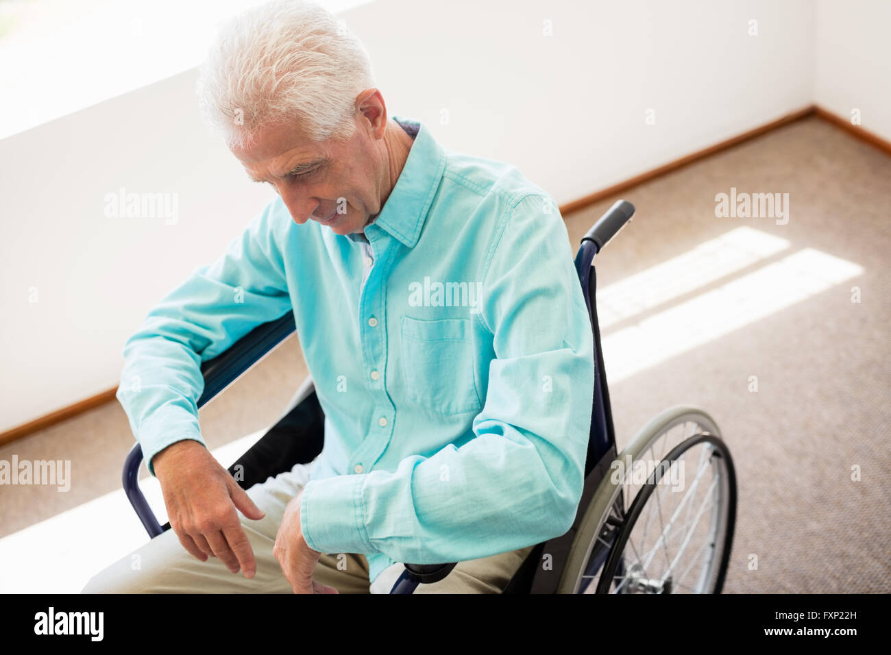 Senior man sitting in a wheelchair Stock Photo