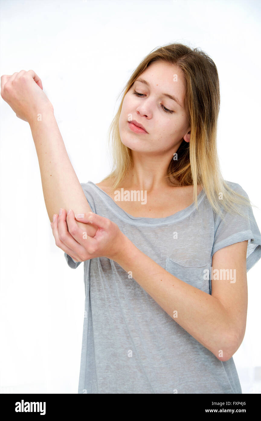 MODEL RELEASED. Young woman touching her elbow Stock Photo Alamy