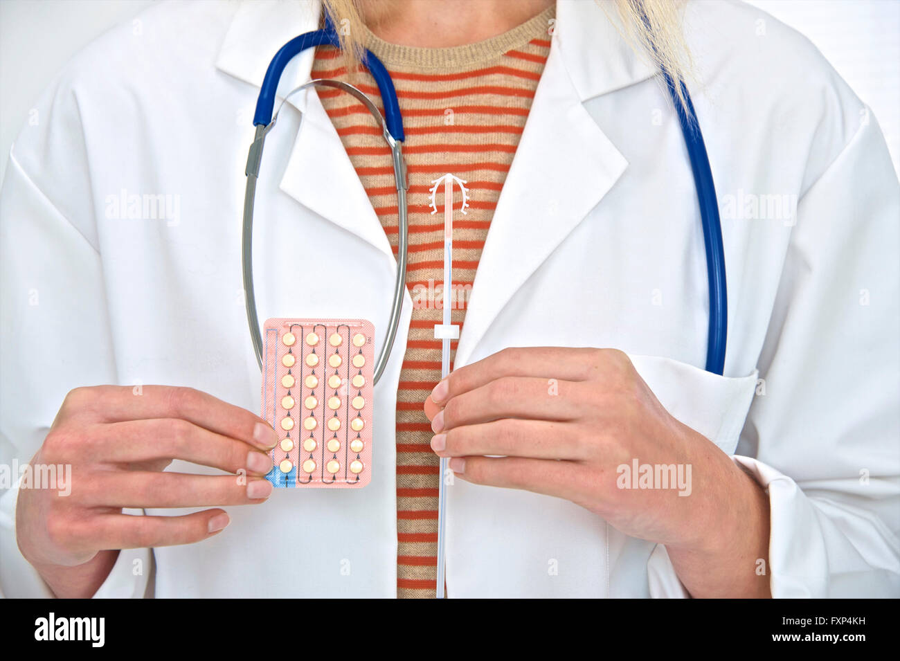 MODEL RELEASED. Female doctor holding intra uterine device and oral contraception pills. Stock Photo