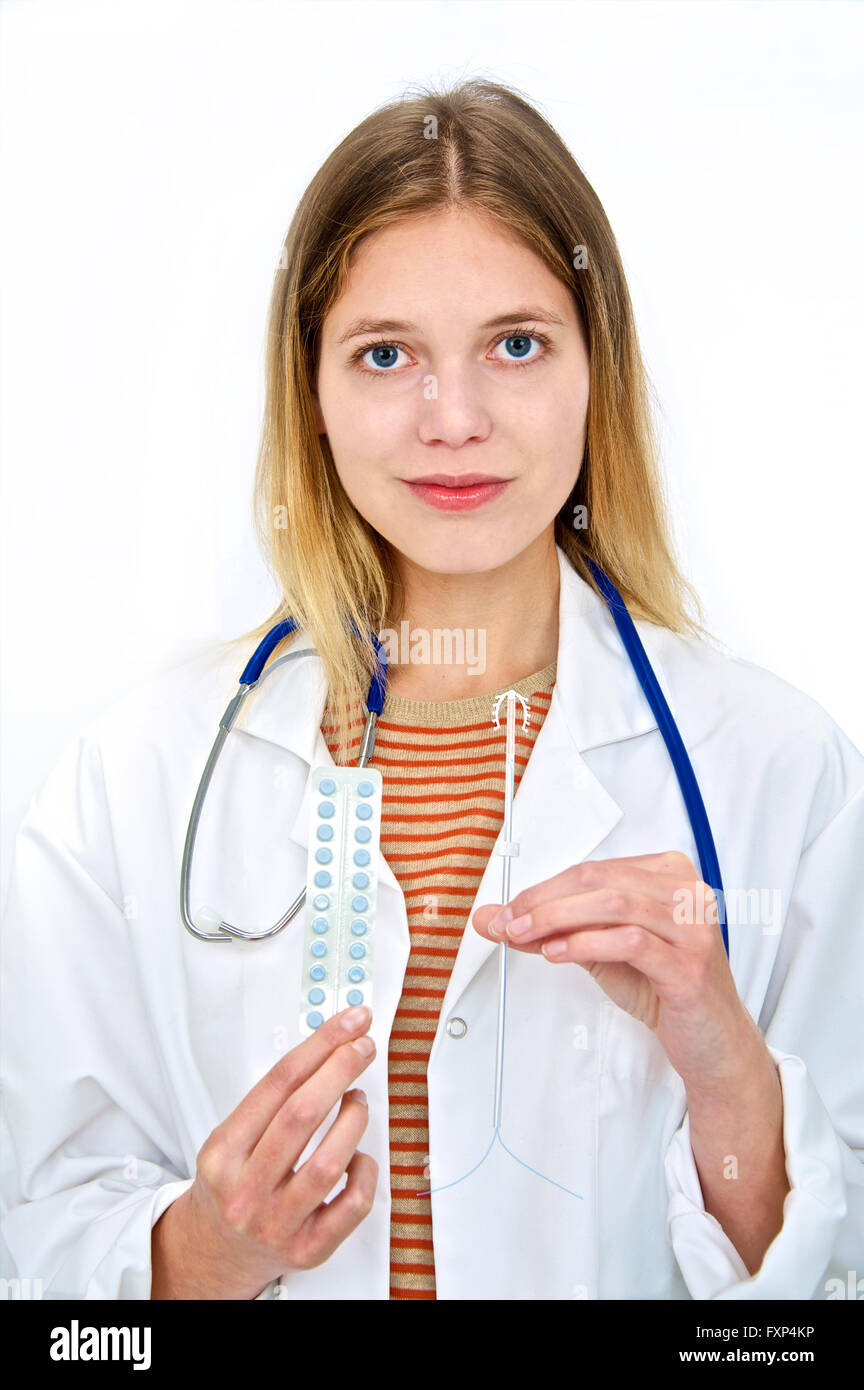 MODEL RELEASED. Female doctor holding intra uterine device and oral contraception pills, portrait. Stock Photo
