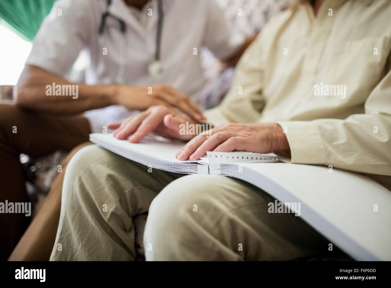 Blind senior man using braille to read Stock Photo
