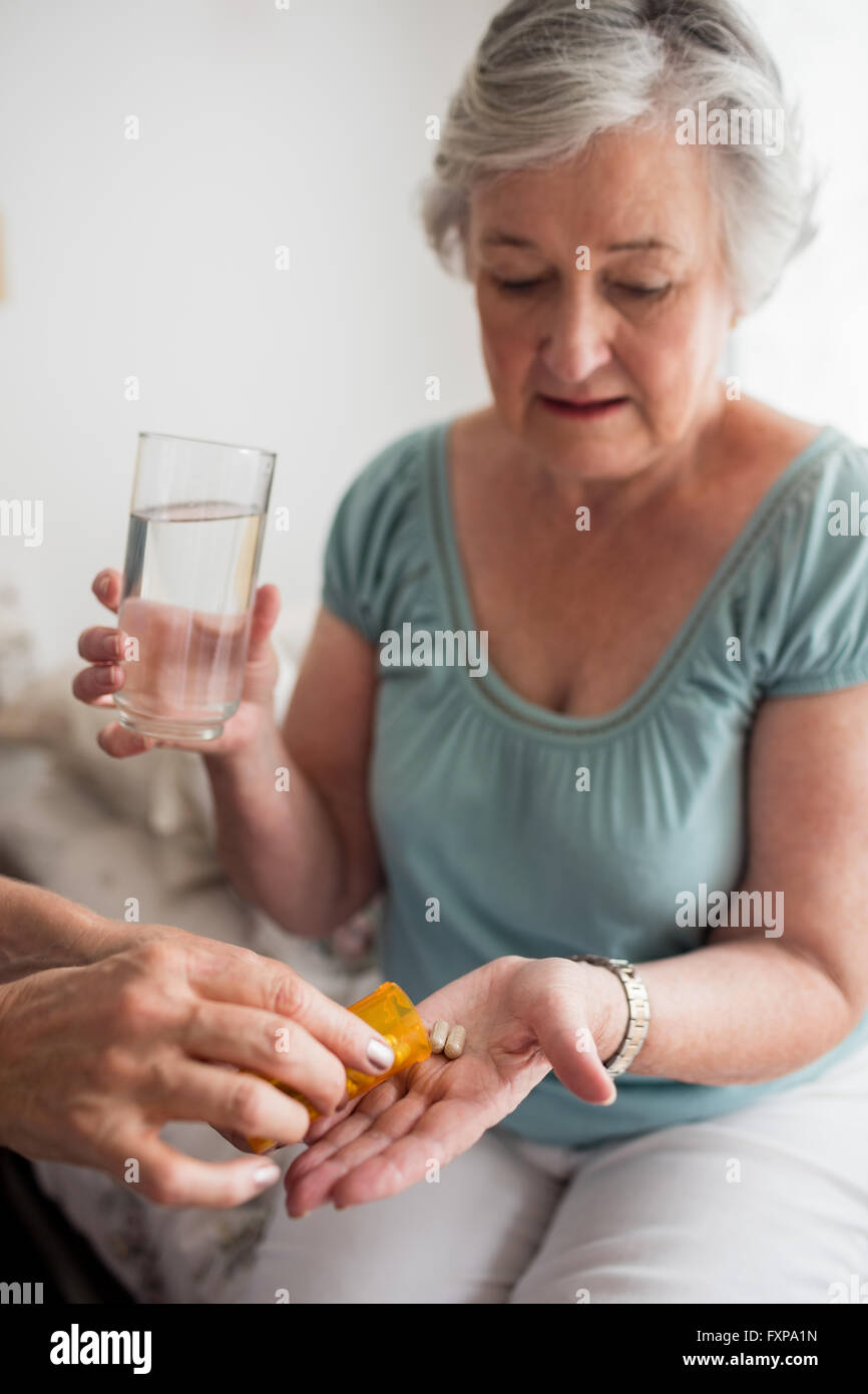 Nurse giving medicaments to a senior woman Stock Photo