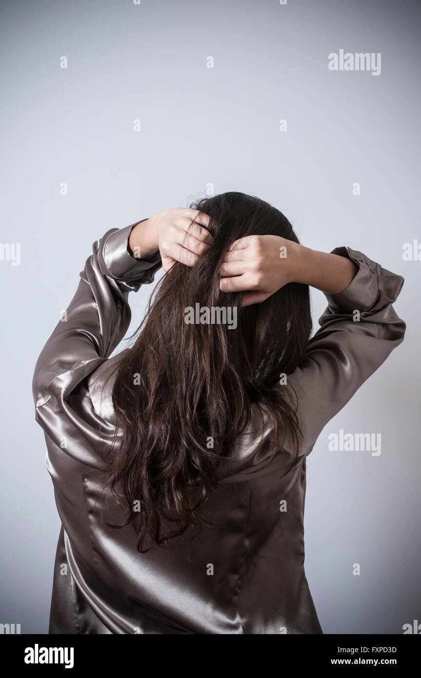Rear view of a young woman hands on head Stock Photo - Alamy