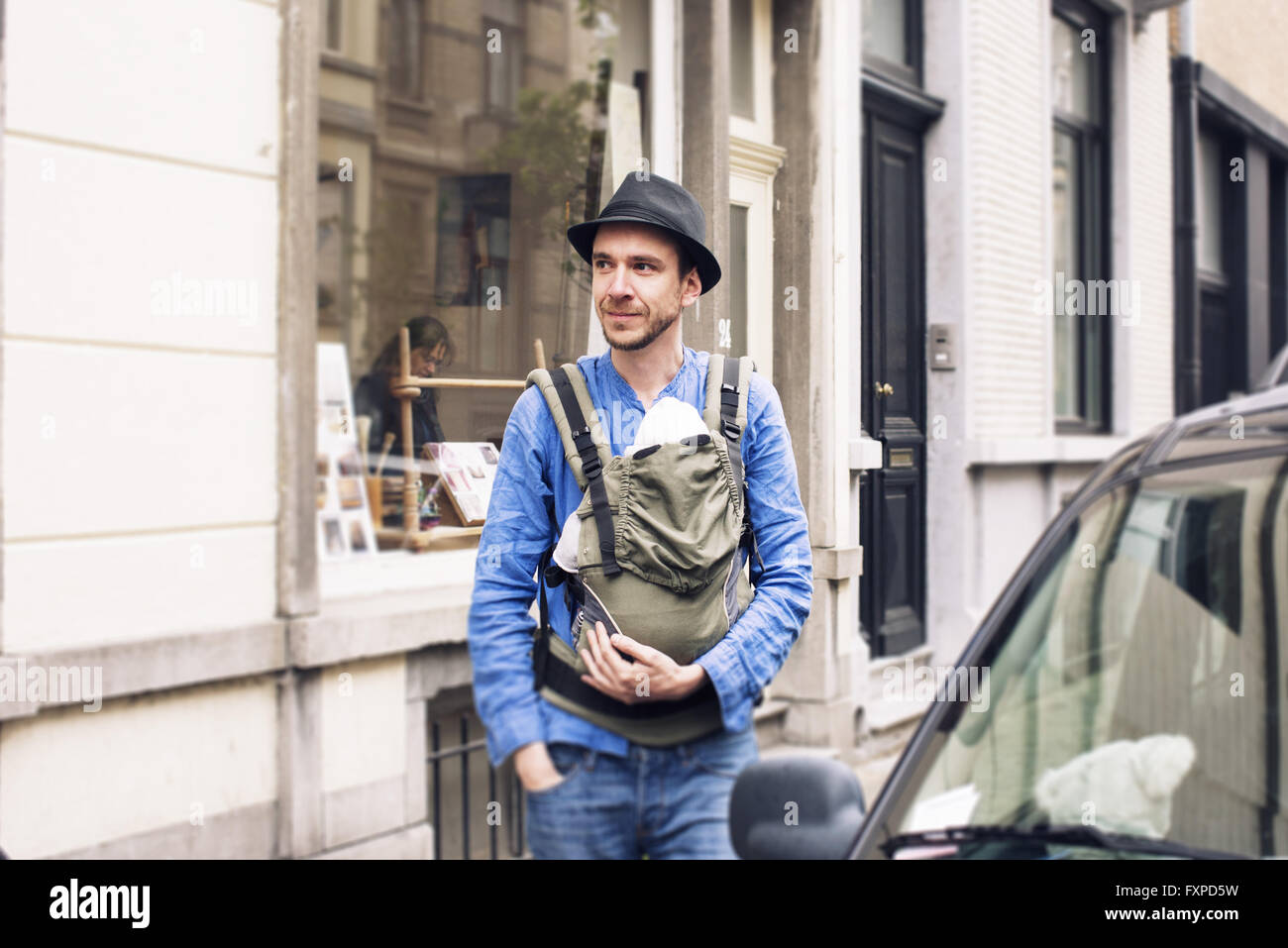 Man with baby in carrier on the move in the city Stock Photo