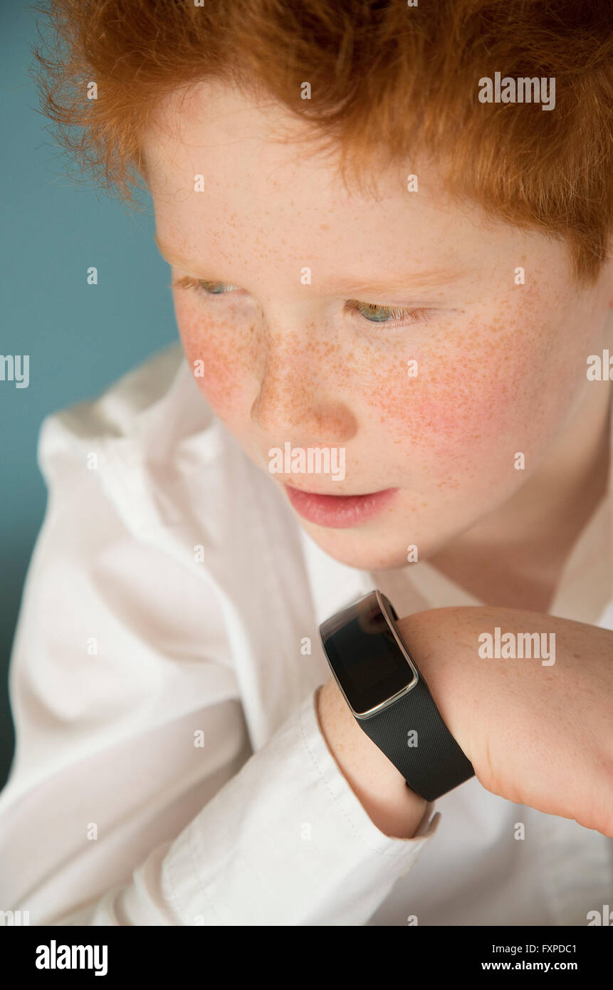 Boy speaking into smartwatch Stock Photo
