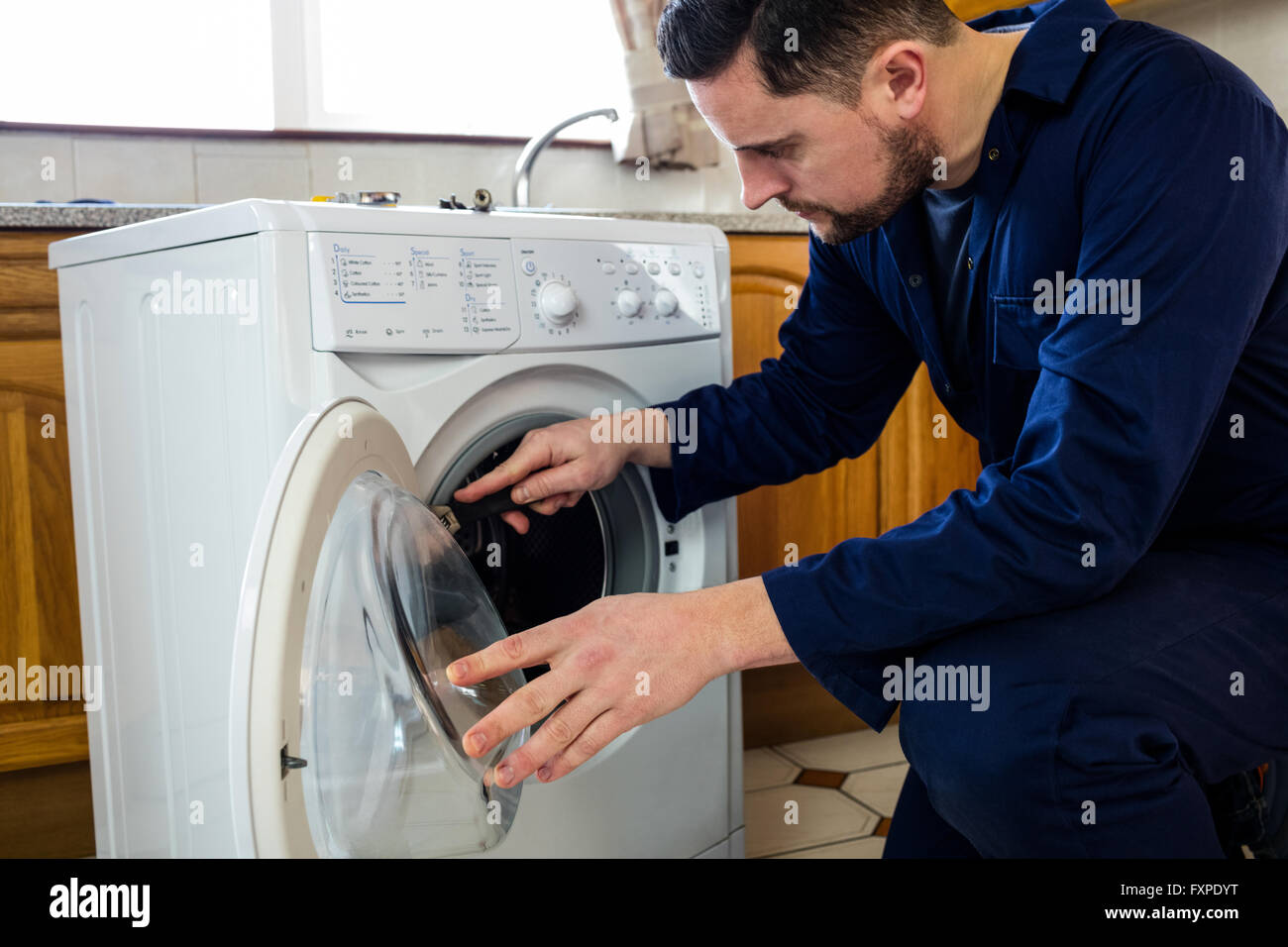Handyman repairing a washing machine Stock Photo Alamy