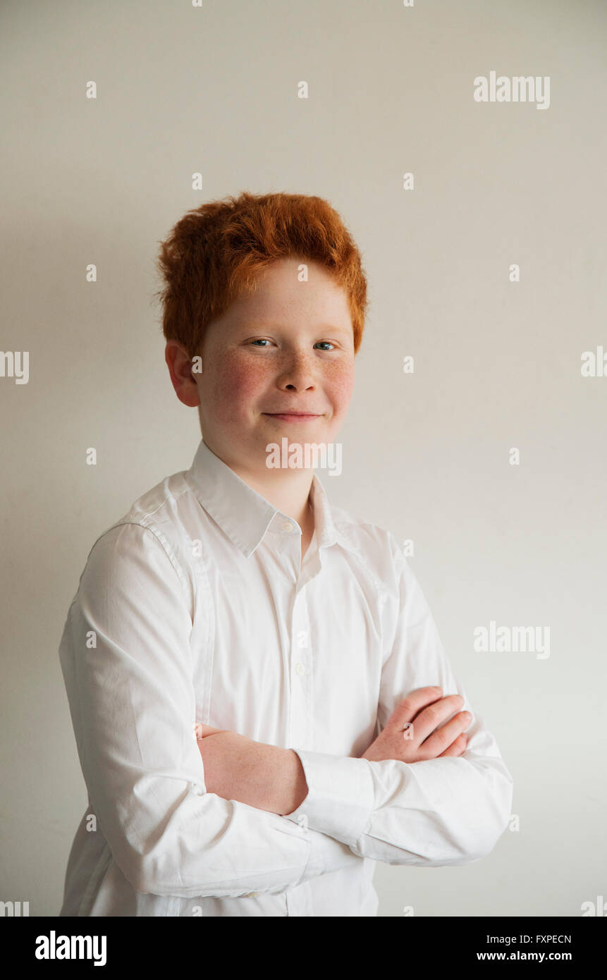 Boy smiling confidently with arms folded, portrait Stock Photo