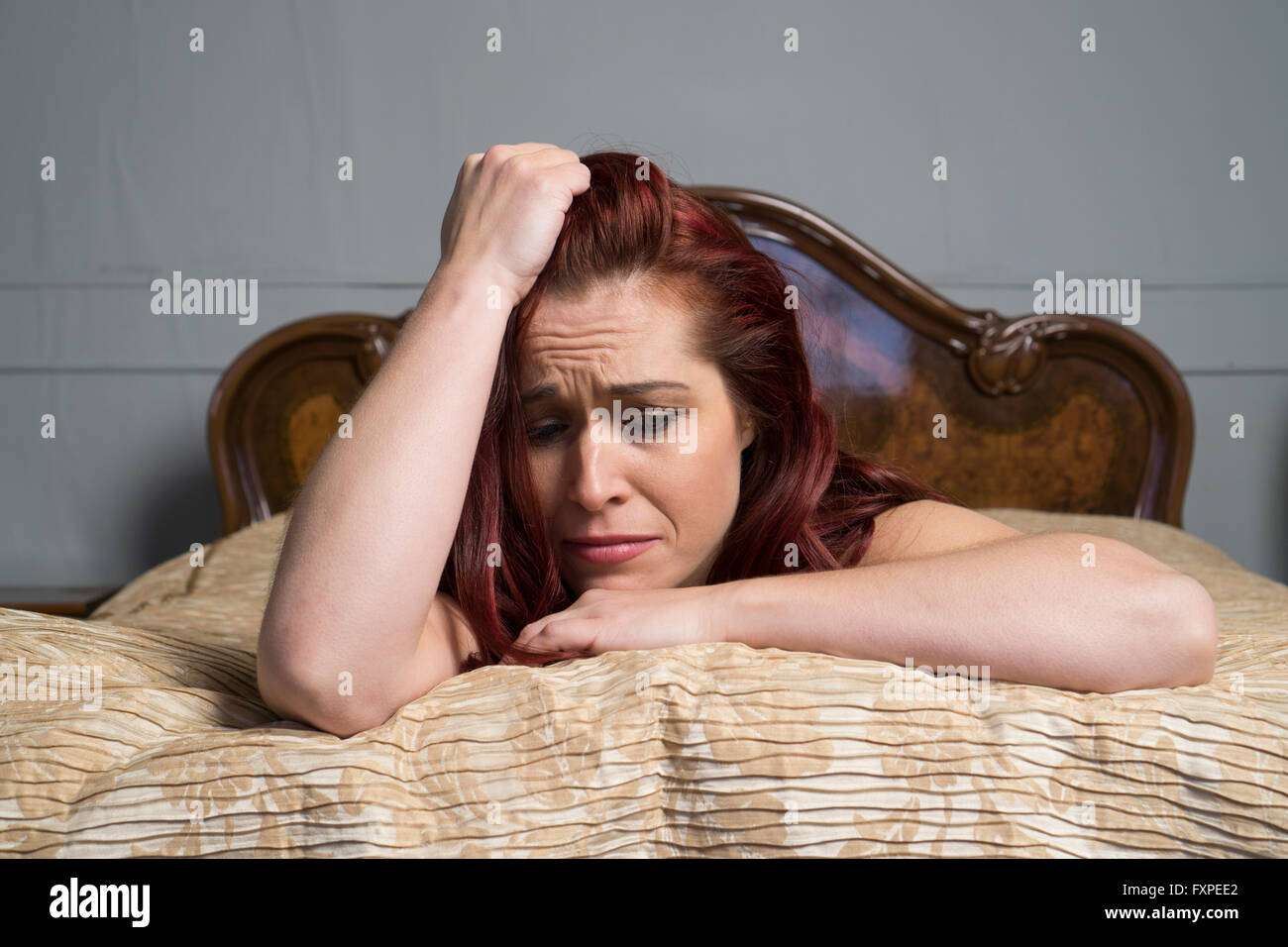 Miserable woman in bed Stock Photo