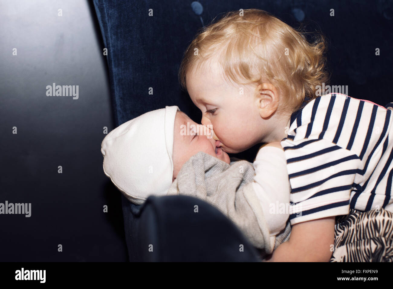 Toddler embracing infant sibling Stock Photo