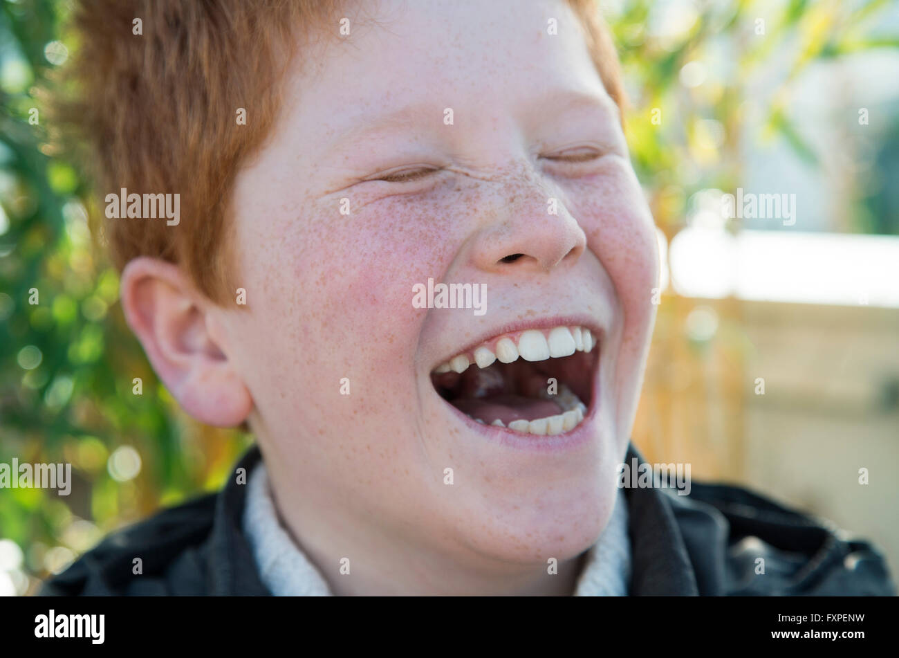 Boy laughing with eyes closed, portrait Stock Photo