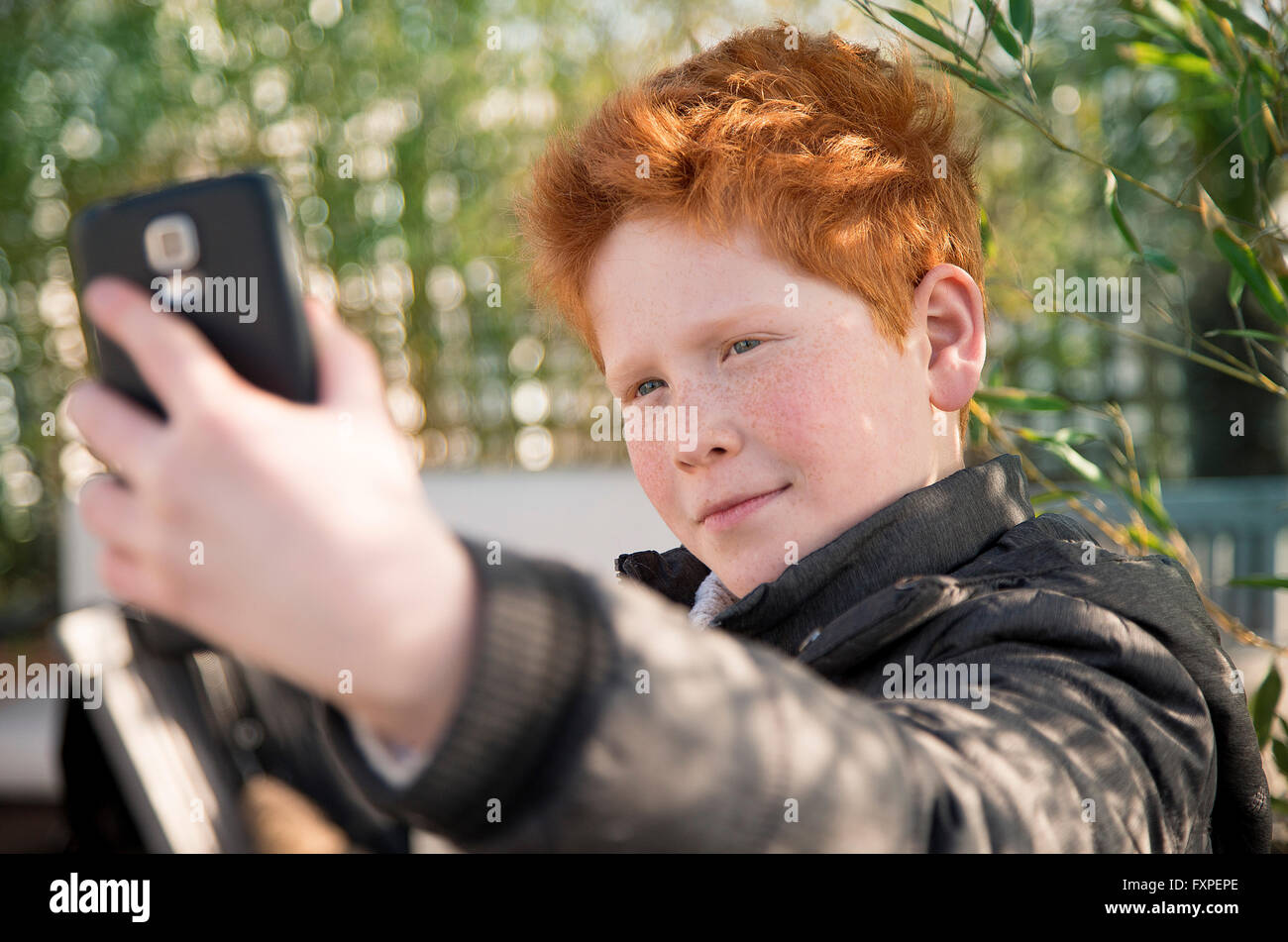 Boy using smartphone to take a selfie Stock Photo