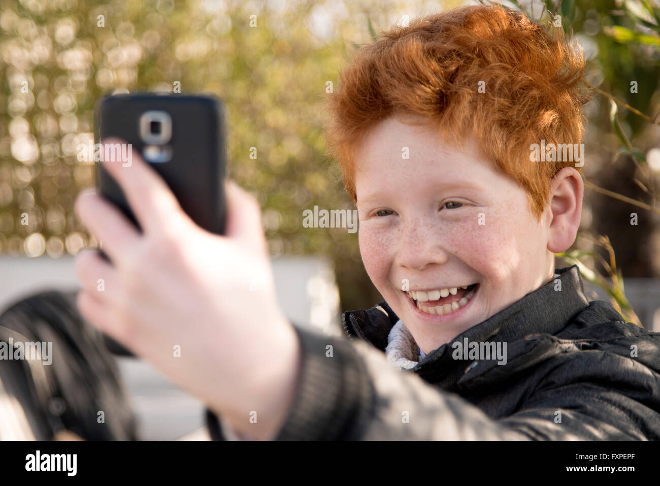 Boy using smartphone to take a selfie Stock Photo