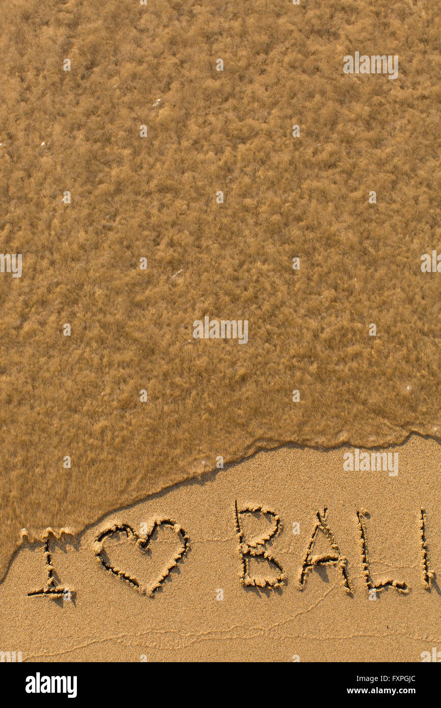 I love Bali - phrase written by hand on the beach with soft waves. Stock Photo