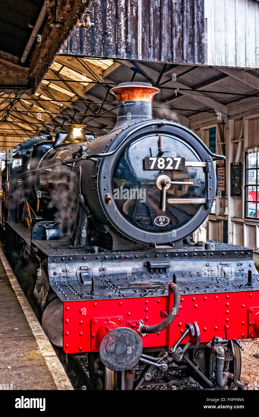 The restored steam locomotive Lydham Manor stands alongside the platform in the  wooden train shed of Kingswear Railway Station Stock Photo
