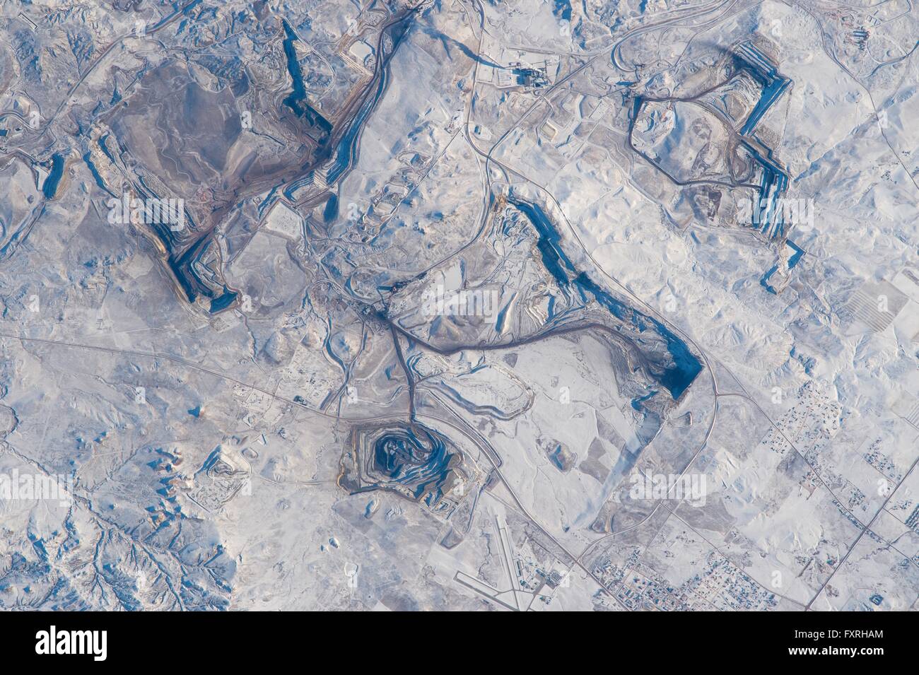 International Space Station view looking down from space at open-cast pits of several coal mines that operate out of the small town of Gillette, Wyoming contrasted agains the wintery snow covered landscape of the Bighorn Mountains. Stock Photo