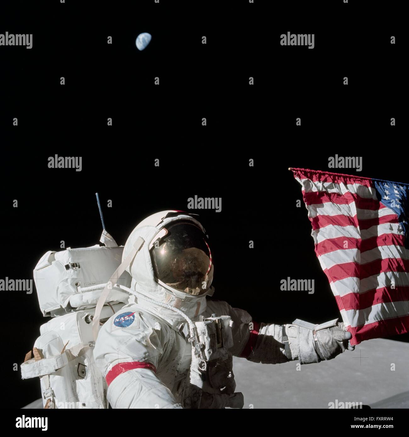 NASA astronaut and Apollo 17 commander Eugene A. Cernan is holding the lower corner of the American flag during the first EVA on the lunar surface December 12, 1972. Apollo 17 is the final lunar landing mission scheduled. Stock Photo