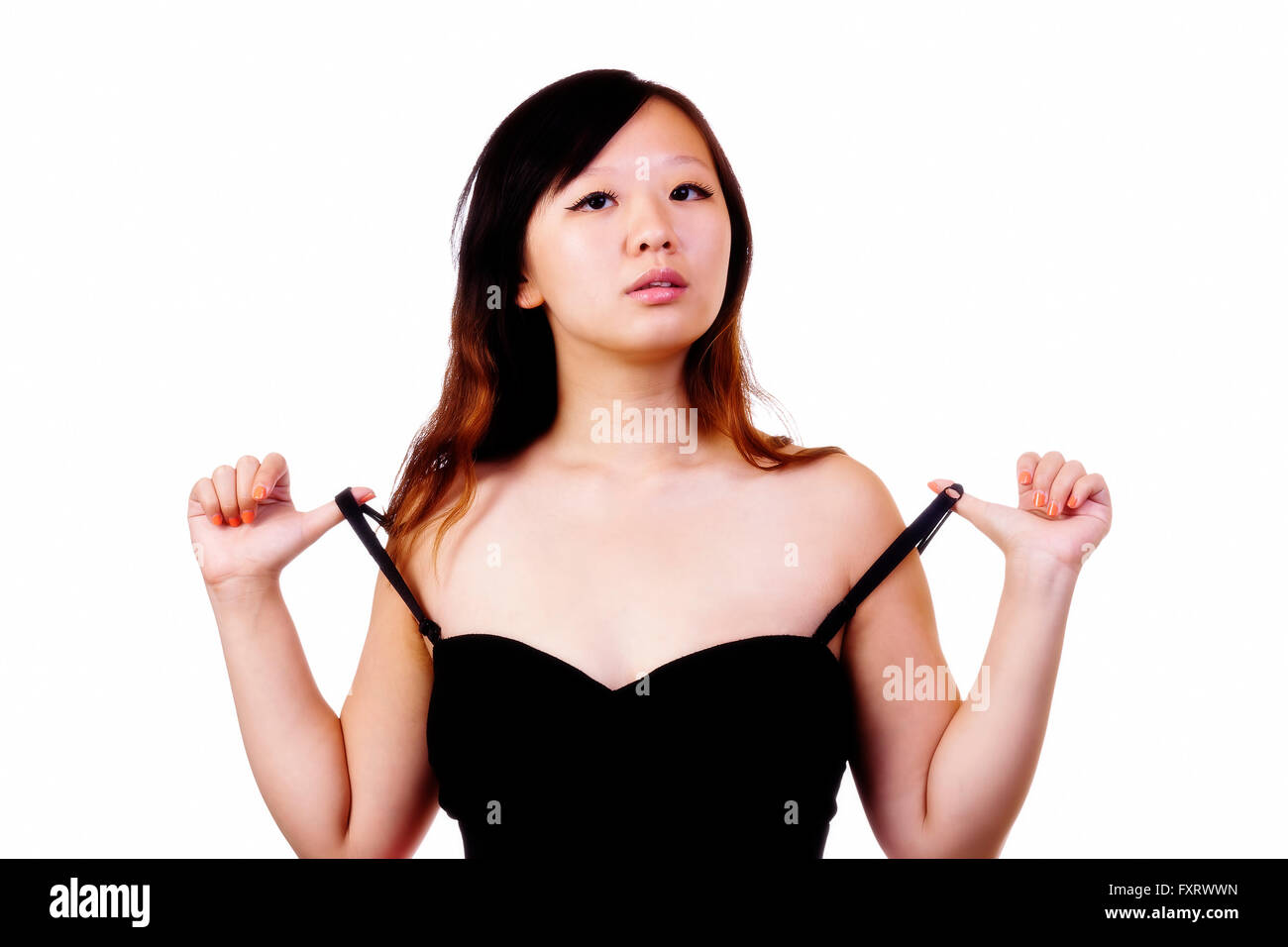 Chinese American Woman Pulling On Black Dress Straps Stock Photo