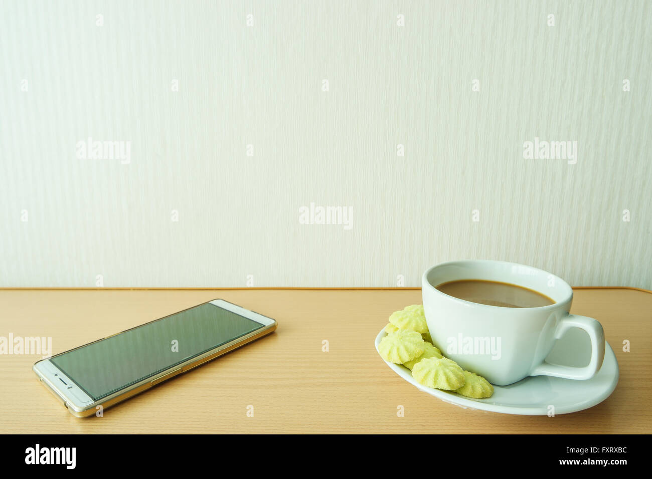 Coffee in cups with candy and white phones. Stock Photo