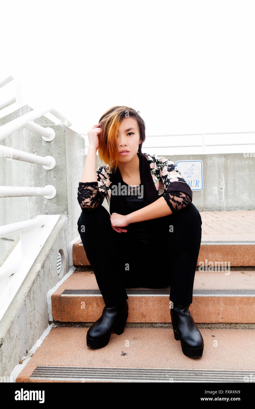 Asian American Woman Sitting On Steps Pants Stock Photo