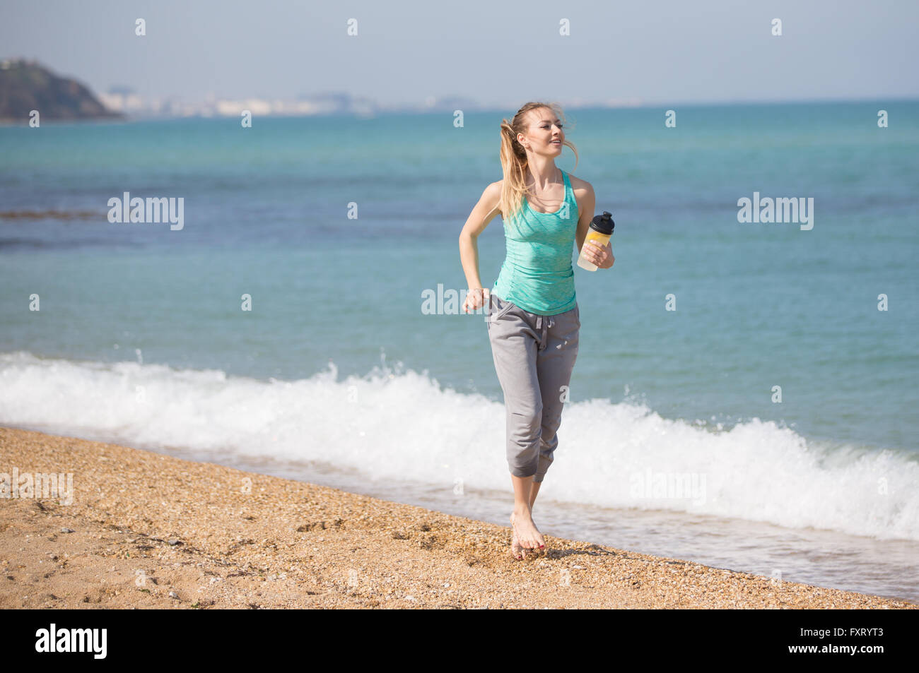 Young woman running on the beach Stock Photo Alamy