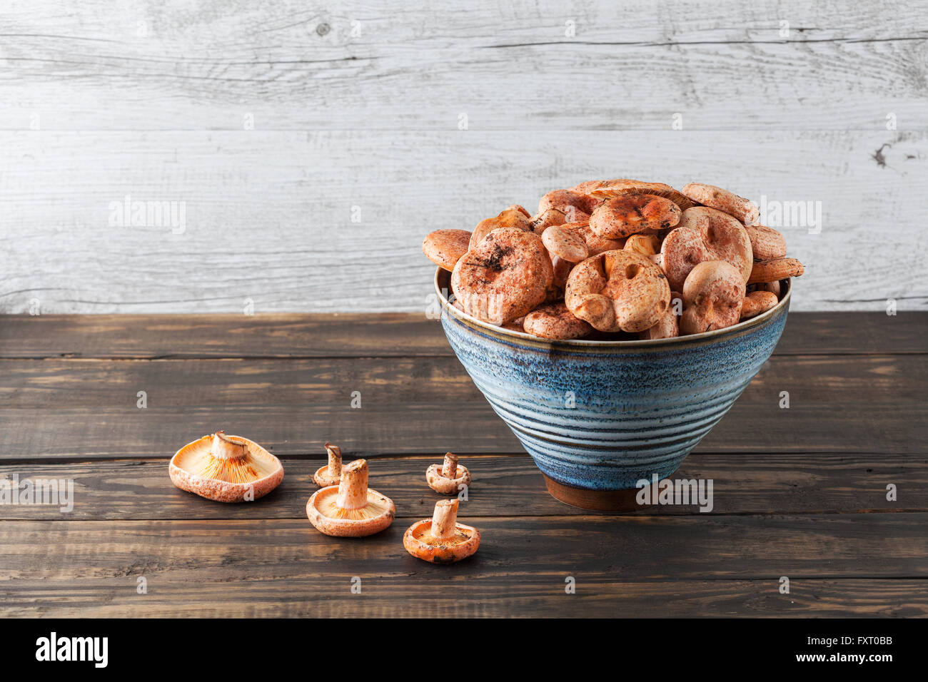 Orange edible mushrooms - Saffron Milk Cap in ceramic bowl on wooden table with copy space Stock Photo