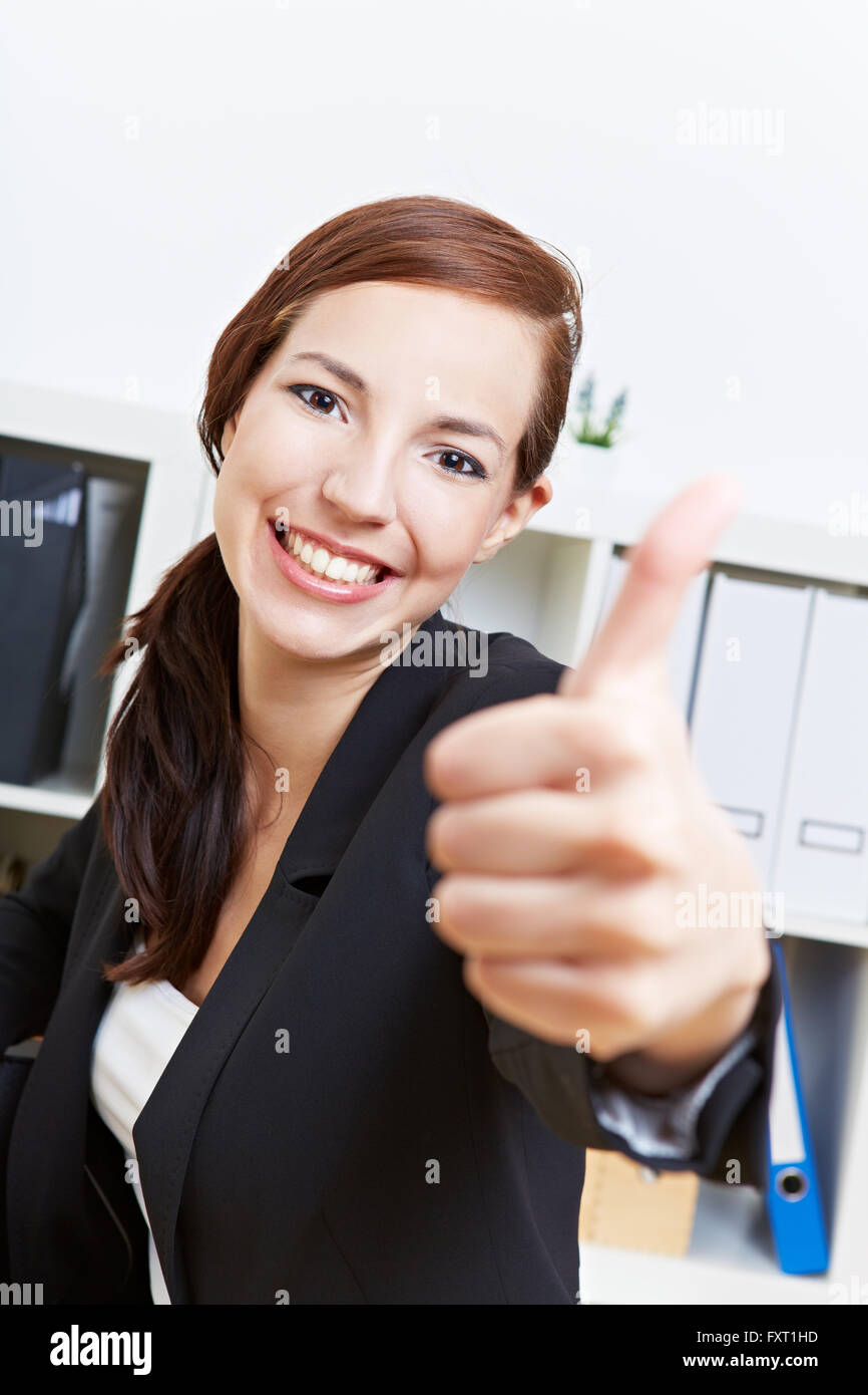 Happy businesswoman holding her thumbs up in the office Stock Photo - Alamy